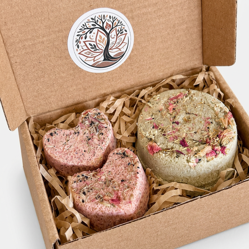 Tightly framed open gift box containing three botanical shower steamers